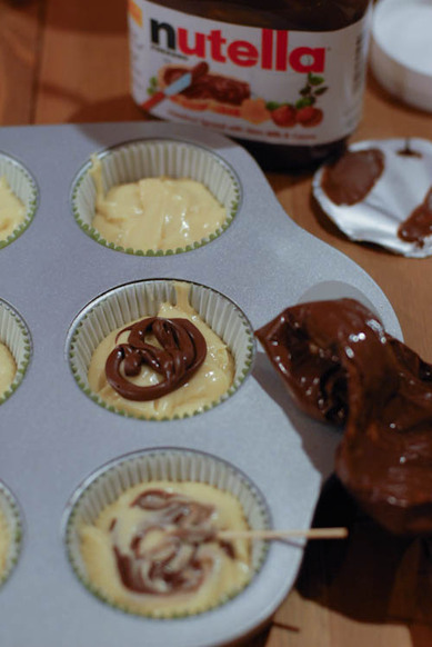 piping nutella onto cupcakes